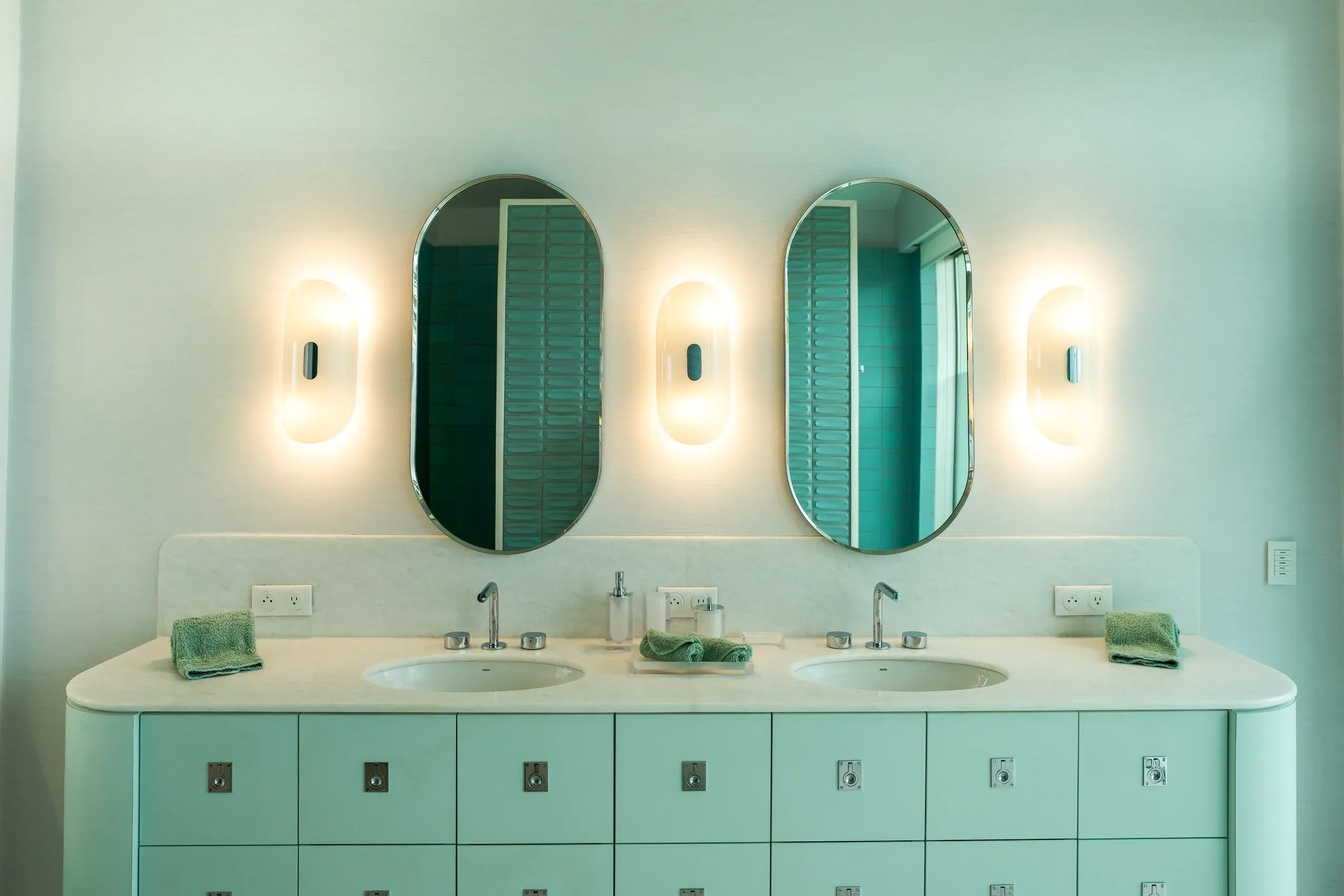 Twin vanities in mint with oval mirrors