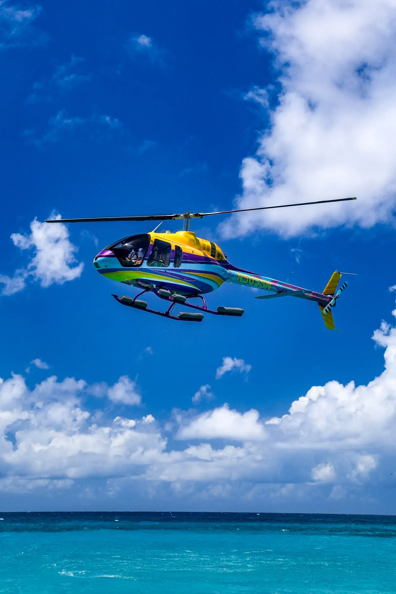 The Bell 505 hovering over the Speed Boat at sea