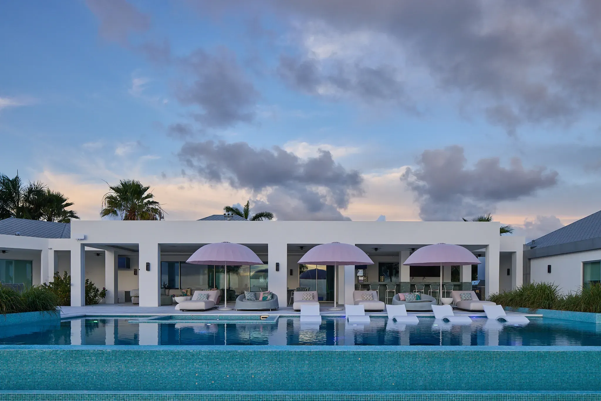 The villa and pool glowing at dusk