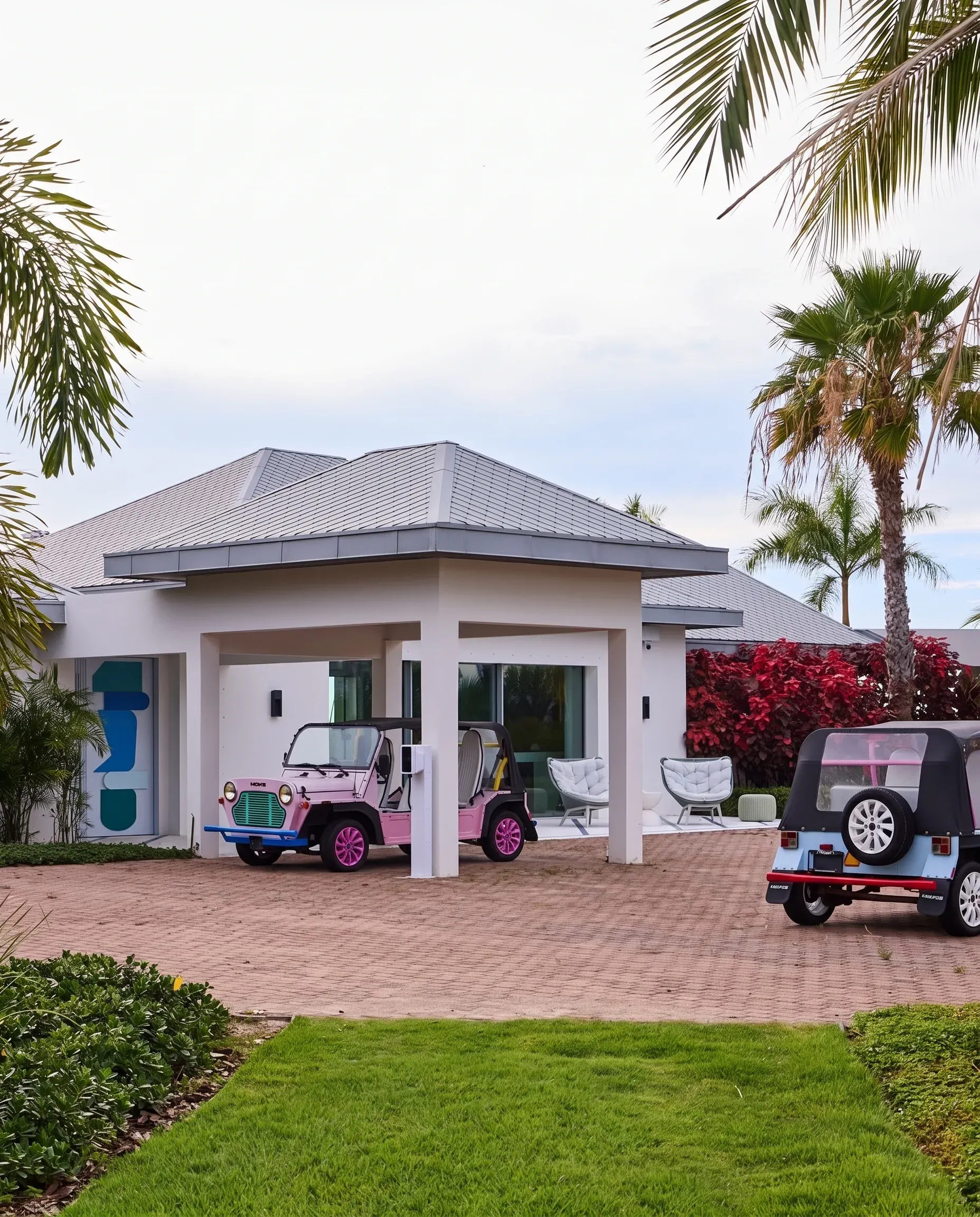 Moke cars at the palm-lined entrance of the main house